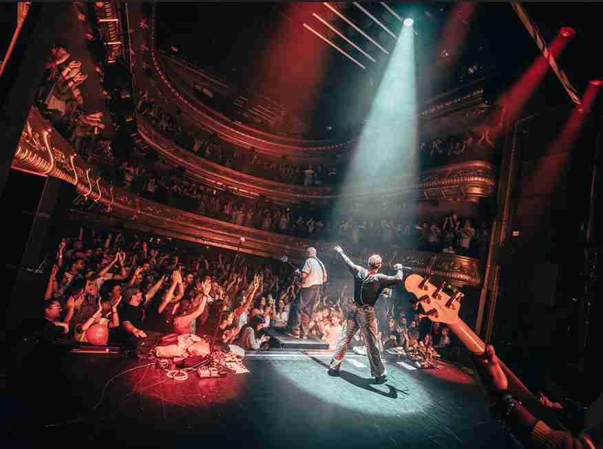 La banda Sobrezero actuando en directo sobre el escenario ante un Teatro Eslava abarrotado en Madrid.